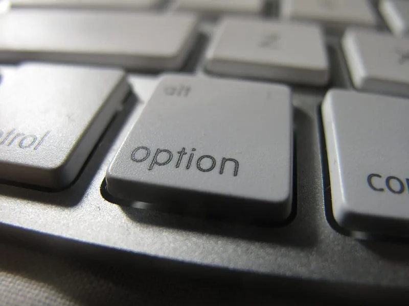 Close-up of a silver keyboard with the option key in focus beside control and command keys