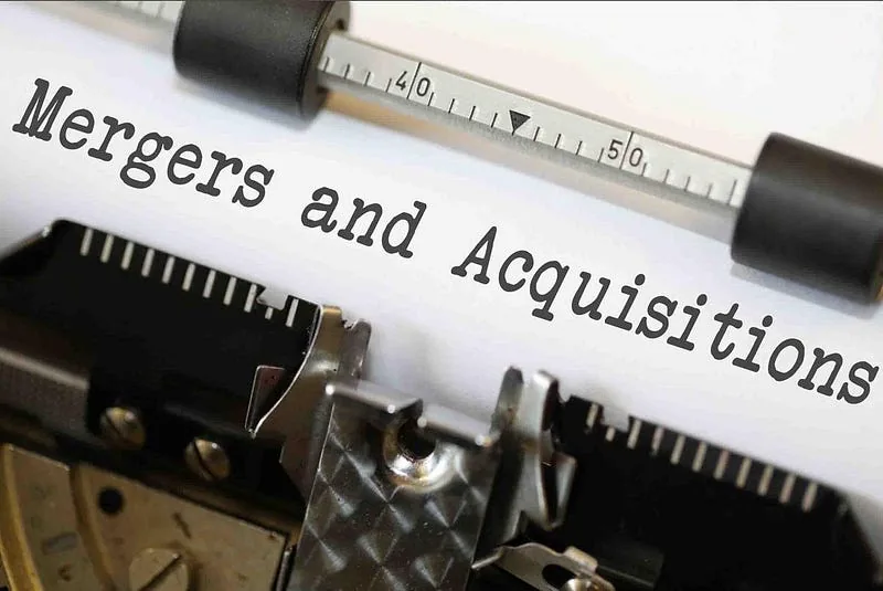 Close-up of "Mergers and Acquisitions" typed on white paper in a vintage typewriter